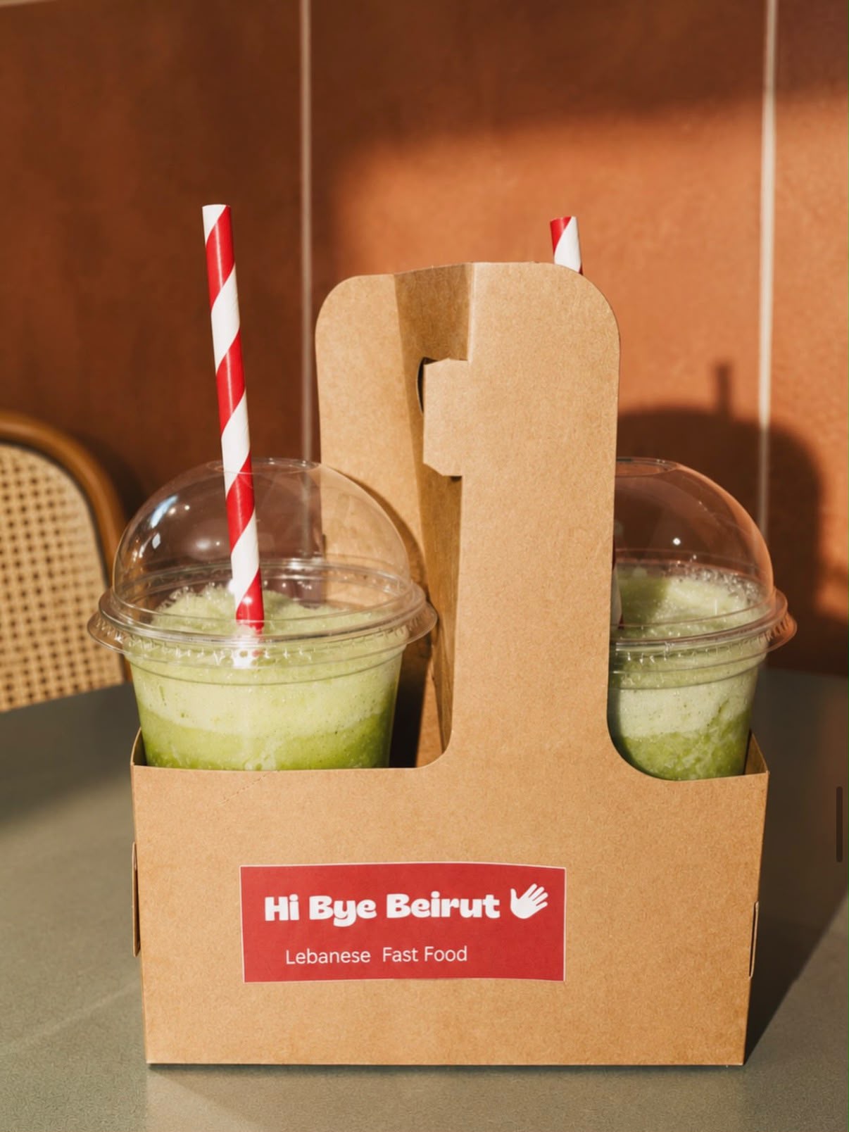 Deux limonades vertes avec pailles rayées dans un porte-gobelets kraft Hi Bye Beirut
